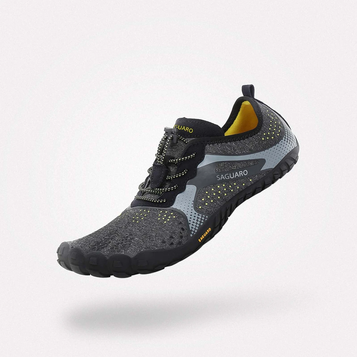 Zapatilla barefoot Saguaro modelo Fast I en color negro con detalles grises y amarillos, vista lateral destacando diseño minimalista y suela ergonómica para trail.
